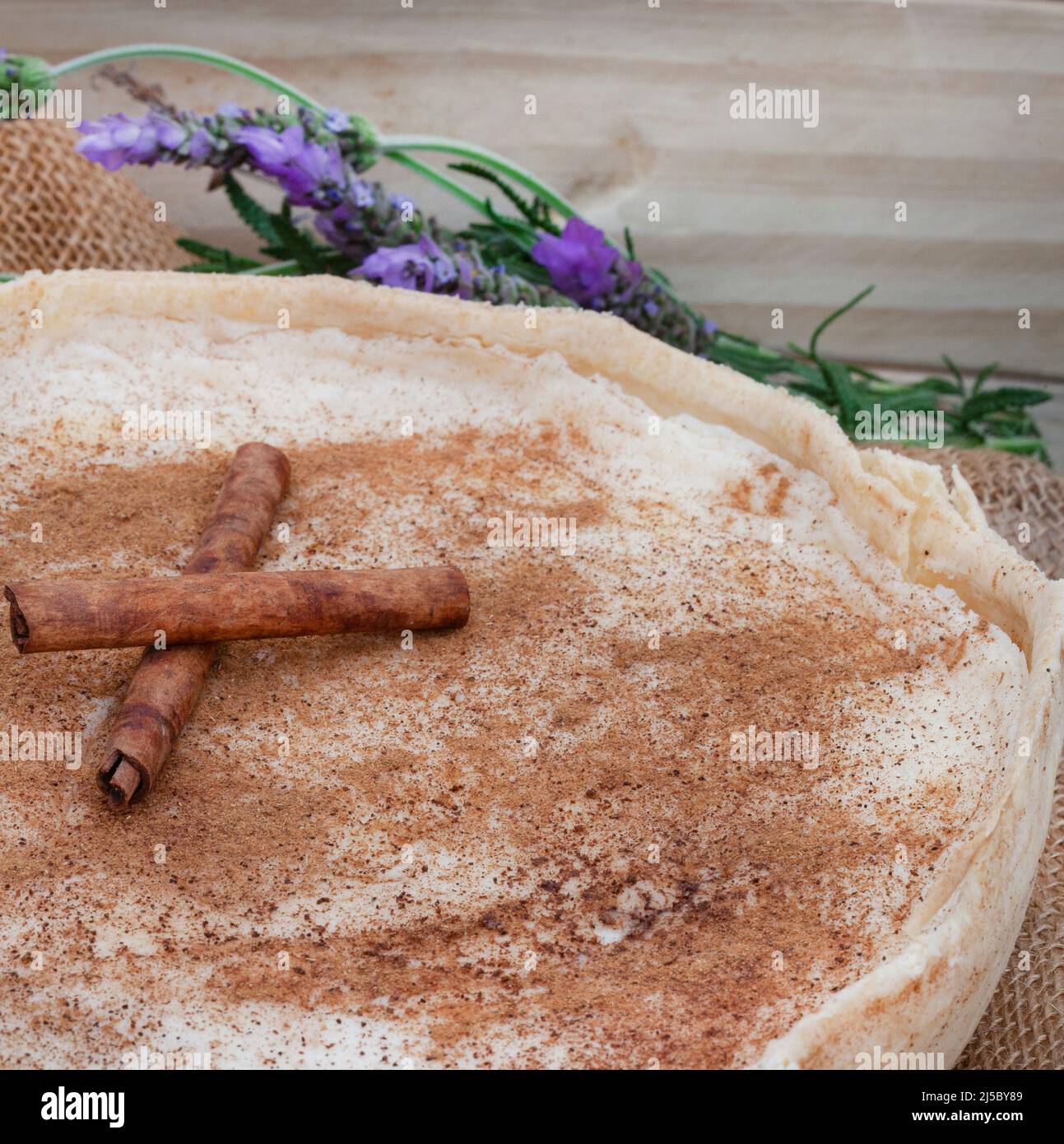 Crostata al latte al forno. Una versione al forno della tradizionale crostata al latte sudafricana o melktert, con cannella e tavola rustica Foto Stock