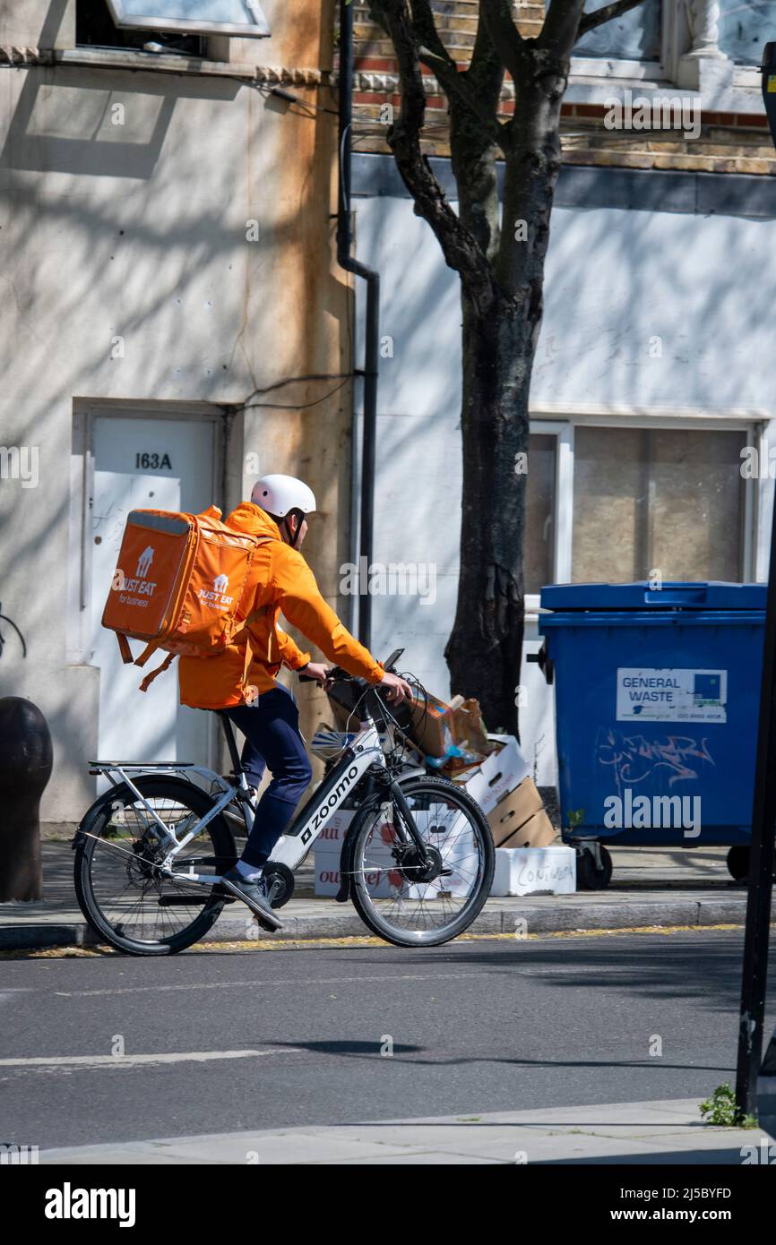 Basta mangiare autista di consegna su una bicicletta Foto Stock