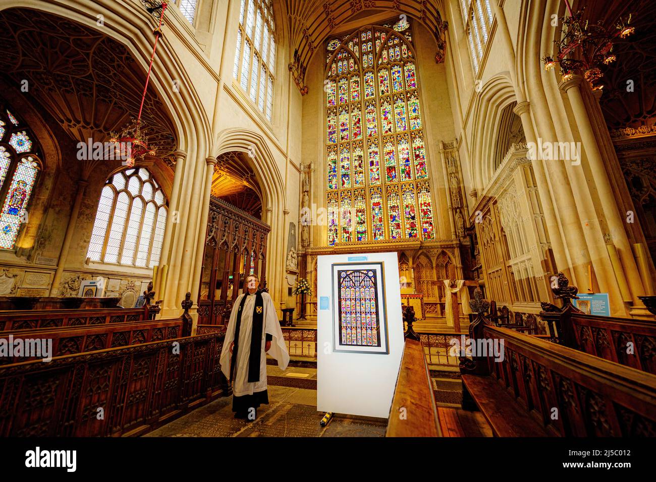 Il reverendo Canon Guy Bridgewater attraversa l'abbazia di Bath e passa accanto a un'intricata opera d'arte in vetro colorato in mostra dall'artista Shelley Ashkowski in una mostra di oltre 20 pezzi che celebra la storia e la bellezza di chiese, cattedrali e abbazie. Ogni pezzo si ispira all'architettura di questi edifici e a molti studi complessi di vetrate colorate, tra cui una delle grandi finestre orientali dell'Abbazia di Bath che racconta la storia della vita di Gesù in 56 scene. Data foto: Domenica 22 ottobre 2017. Il credito fotografico deve essere: Ben Birchall/PA Wire Foto Stock