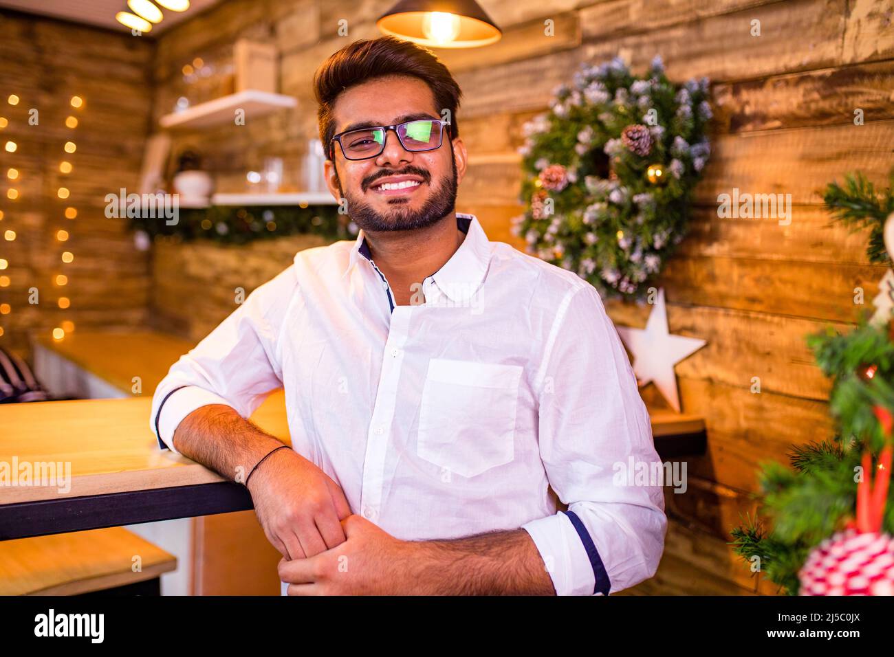 l'uomo indiano che decora l'albero di natale da solo auto-isolamento quarantena corona virus covid focolaio soggiorno a casa Foto Stock