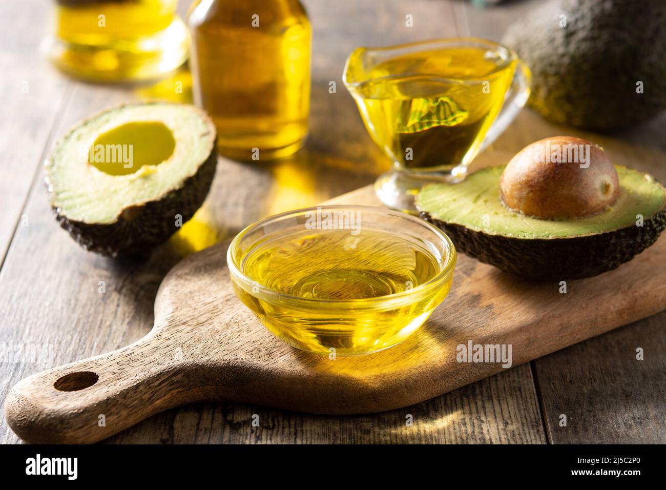 Olio e avocado fresco maturo su tavola rustica in legno Foto Stock