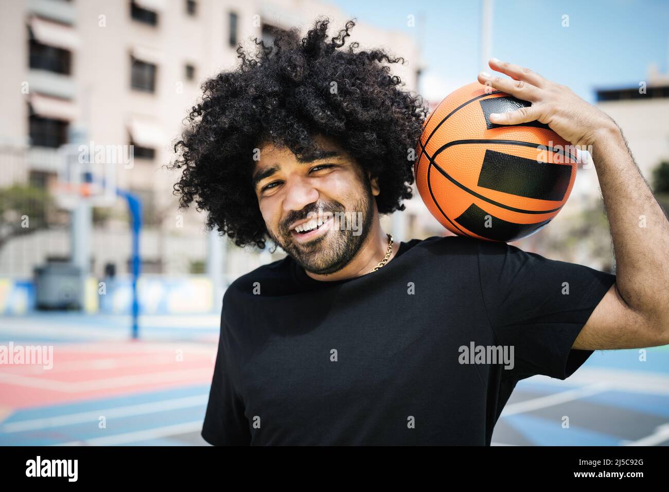 Happy Afro uomo giocare basket all'aperto - Urban sport lifestyle concetto Foto Stock