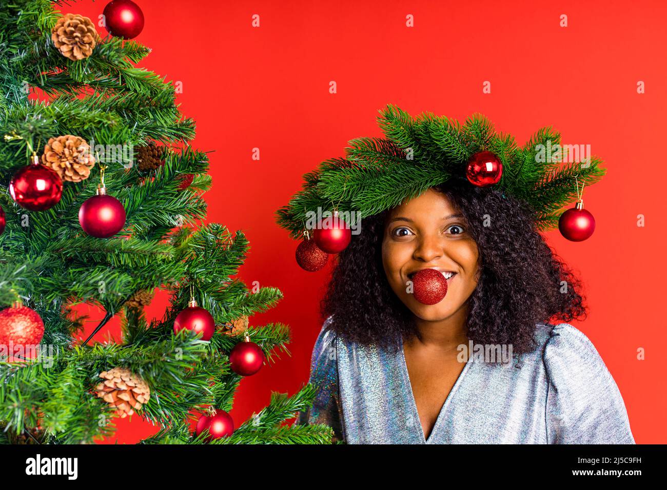 afro spagnolo donna celebrazione natale in abito argento Foto Stock