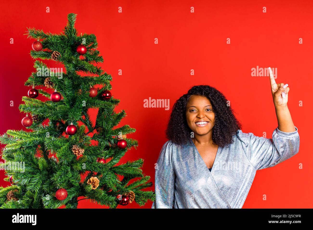 afro spagnolo donna celebrazione natale in abito argento Foto Stock