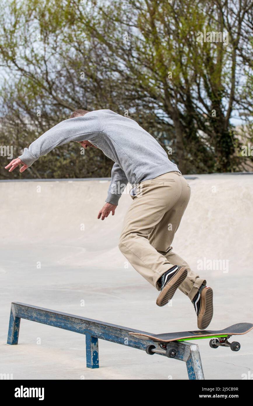 Uno skateboarder maschio maturo non riesce a eseguire un trucco con la ferrovia boardslide al Newquay concrete Waves Skatepark di Newquay in Cornovaglia nel Regno Unito. Foto Stock