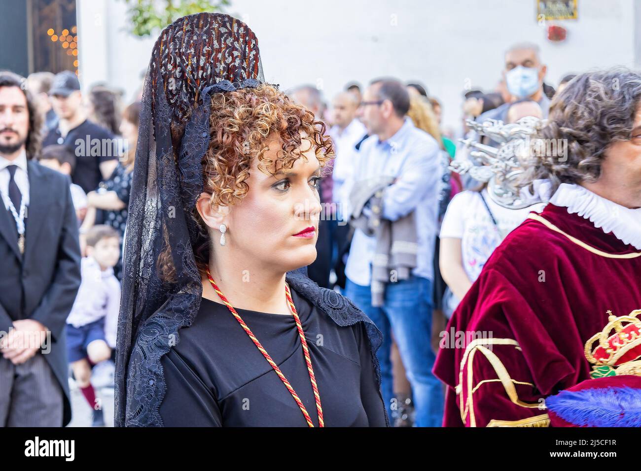 Huelva, Spagna - 15 aprile 2022: Una donna con una mantilla spagnola nera e una peineta (pettine ornamentale), in una processione della settimana Santa Foto Stock