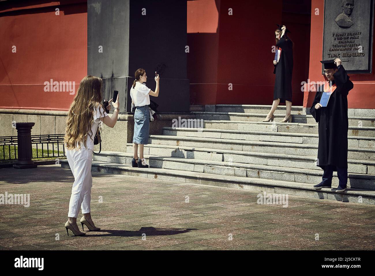 Le giovani donne scattano foto alla cerimonia di laurea di fronte all'ingresso dell'Università di Taras Shevchenko | le giovani donne scattano foto alla cerimonia di laurea di fronte all'ingresso dell'Università di Taras Shevchenko [traduzione automatica] Foto Stock