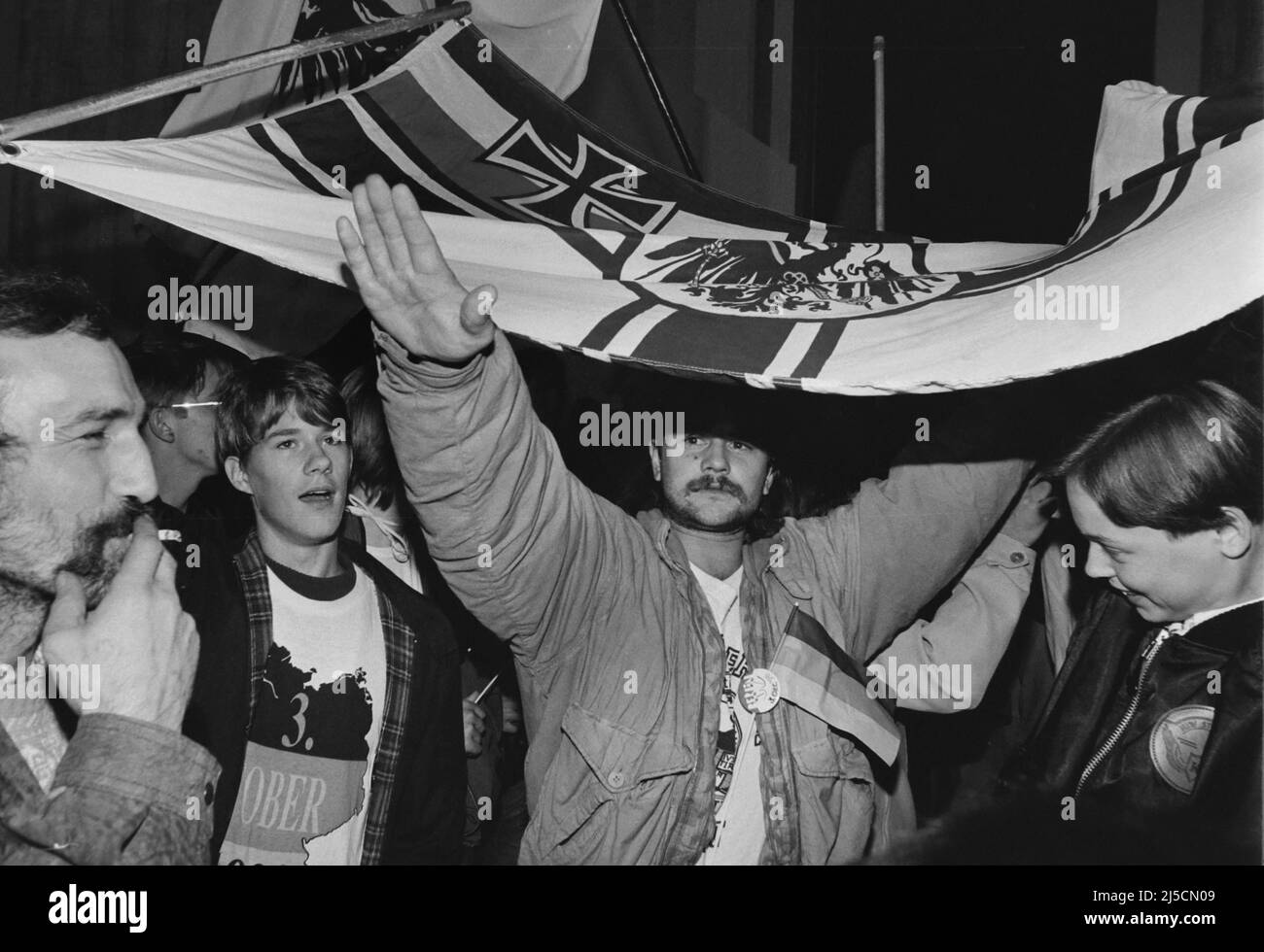 Berlino, DEU, 03.10.1990 - con la bandiera di guerra imperiale e Hitler salutano un uomo si mostra vicino alla porta di Brandeburgo poco dopo la riunificazione della Germania nelle ore mattutine del 03 ottobre 1990. [traduzione automatizzata] Foto Stock