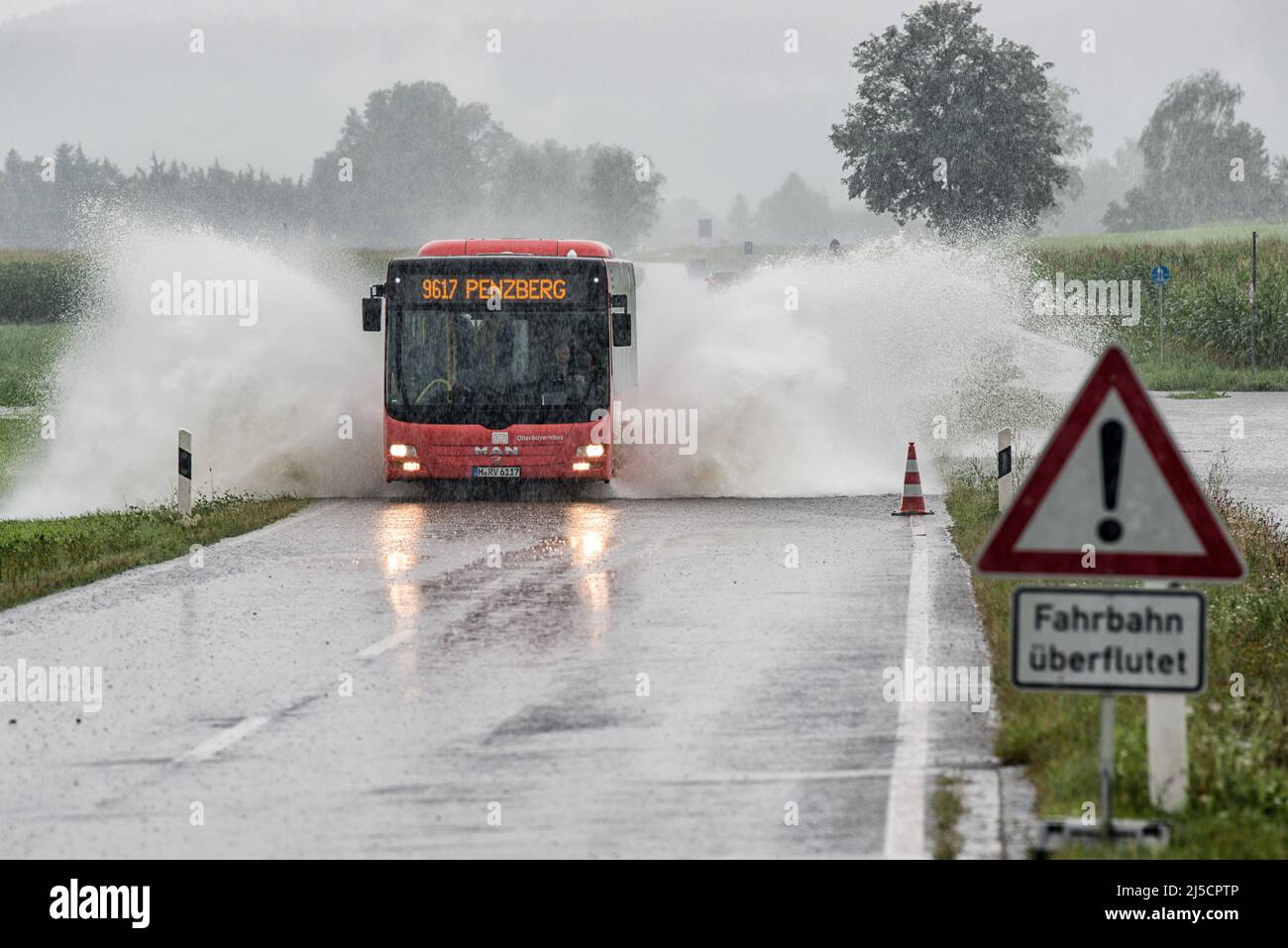 Un autobus percorre la strada allagata tra Penzberg e Sindelsdorf dopo una pioggia pesante persistente. [traduzione automatizzata] Foto Stock