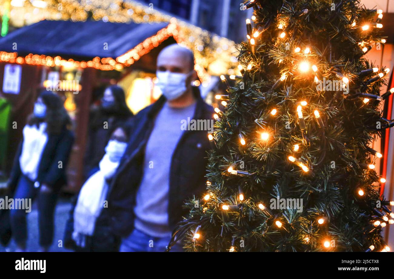 Berlino, DEU, 05.12.2020 - le persone che indossano le maschere passeggiando accanto agli edifici di Natale e alle bancarelle decorate a Natale in una strada commerciale di Berlino. A causa della pandemia di Corona, i ristoranti e i caffè devono rimanere chiusi e la maggior parte dei mercatini di Natale rimarrà chiusa anche quest'anno. [traduzione automatizzata] Foto Stock