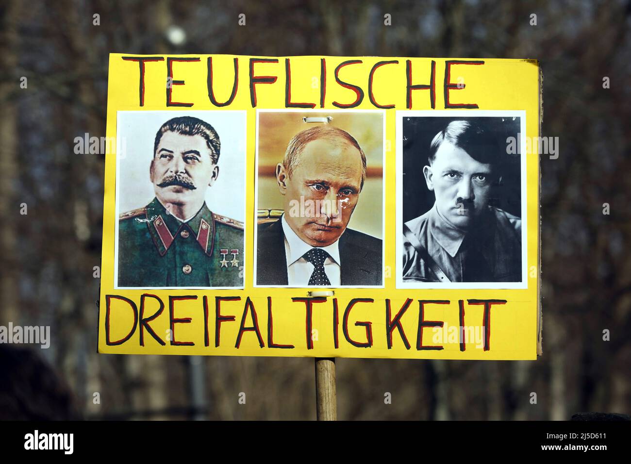 Berlino, 27.02.2022 - Un dimostratore ha una foto con Putin, Hitler e Stalin. Migliaia di persone si dimostrano a Berlino contro la guerra delle truppe russe in Ucraina. [traduzione automatizzata] Foto Stock