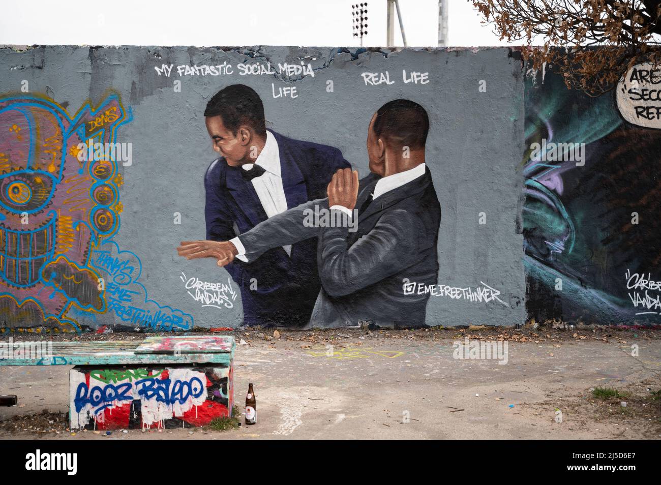 «30.03.2022, Berlino, Germania, Europa - Un graffito dell'artista EME Freethinker su un segmento del Muro di Berlino nel Mauerpark di Berlino nel distretto di Prenzlauer Berg mostra l'attore Will Smith che schiaffa il comico Chris Rock sul palco ai premi dell'Accademia 94th dopo aver fatto divertire sua moglie Jada Pinkett Smith. Will Smith vinse in seguito il primo Oscar nella sua carriera per il ruolo del padre dei giocatori di tennis Venus e Serena Williams nel film ''King Richard''. [traduzione automatizzata]' Foto Stock