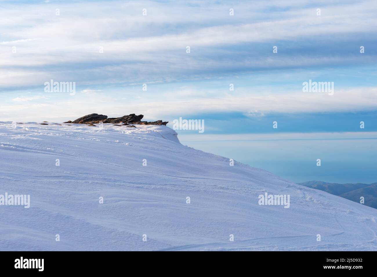 Vista da una cima della Sierra Nevada di alcune rocce in inverno, con tutto innevato. Foto Stock