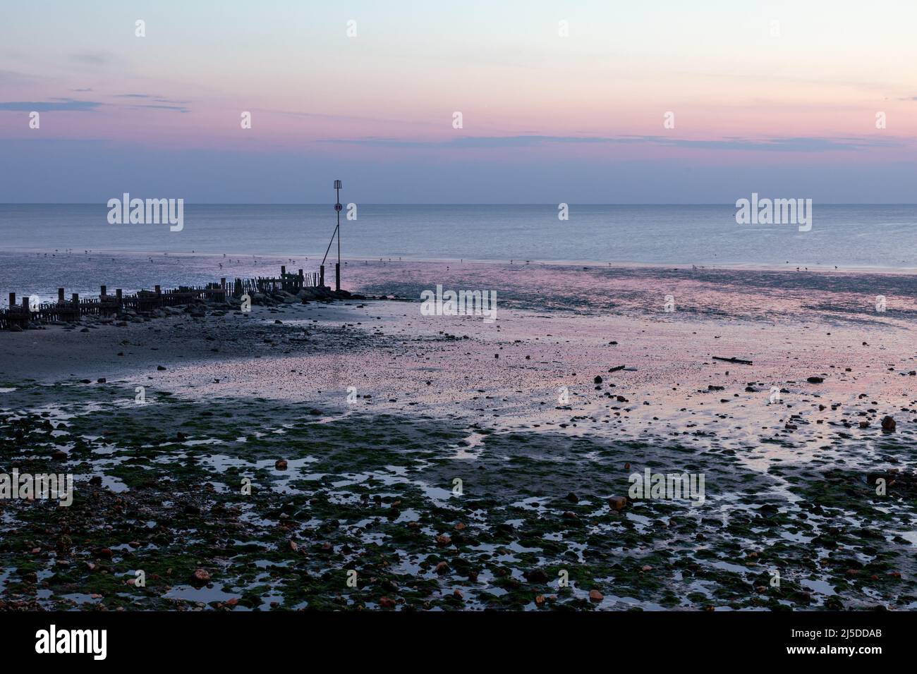 Grotte marine e luce riflessa sulla spiaggia di Hunstanton al tramonto. Foto Stock