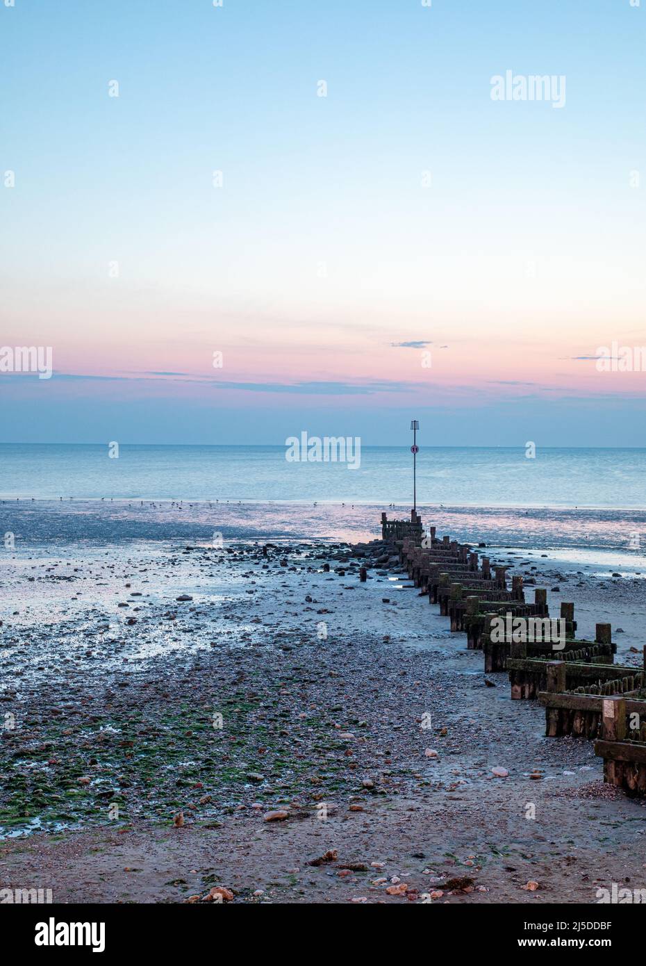 Grotte marine e luce riflessa sulla spiaggia di Hunstanton al tramonto. Foto Stock