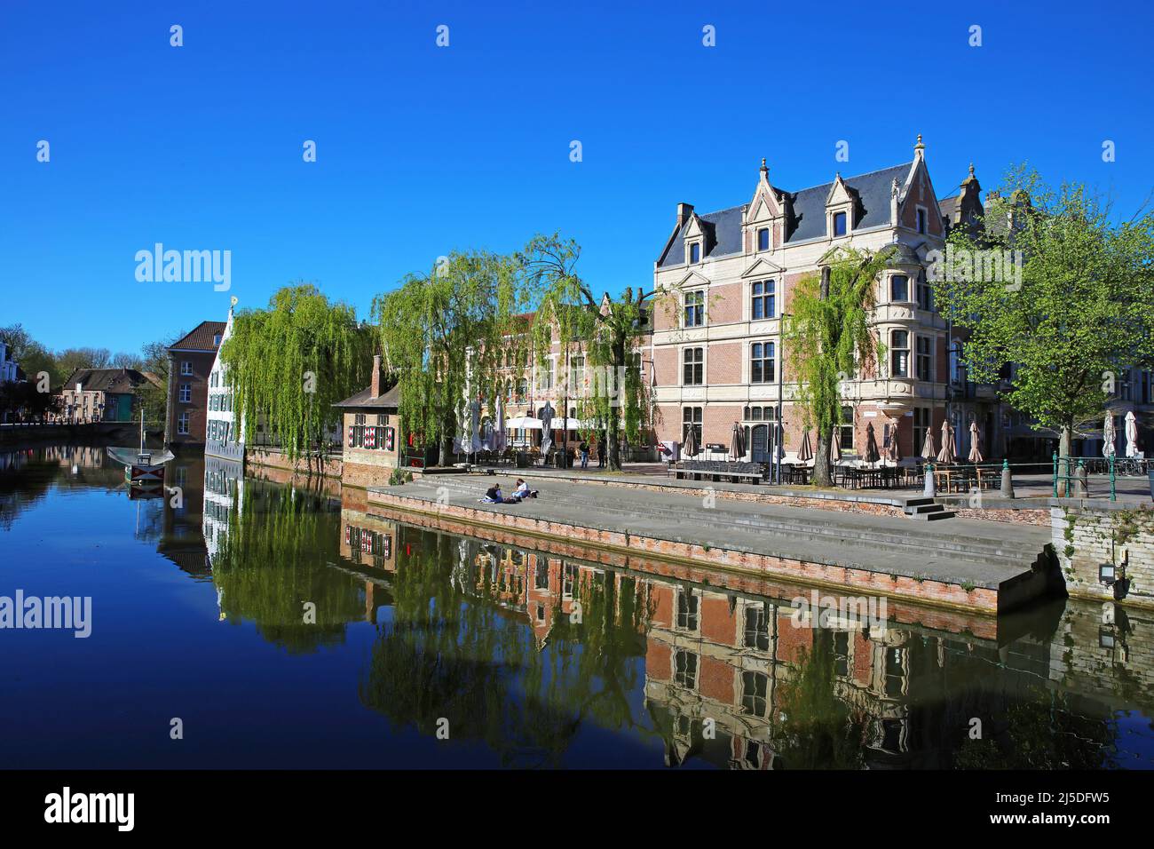 Lier, Belgio - Aprile 9. 2022: Vista sul villaggio acqua fossato su scalini molo barca, edifici antichi, verde piangendo salice alberi, cielo blu Foto Stock