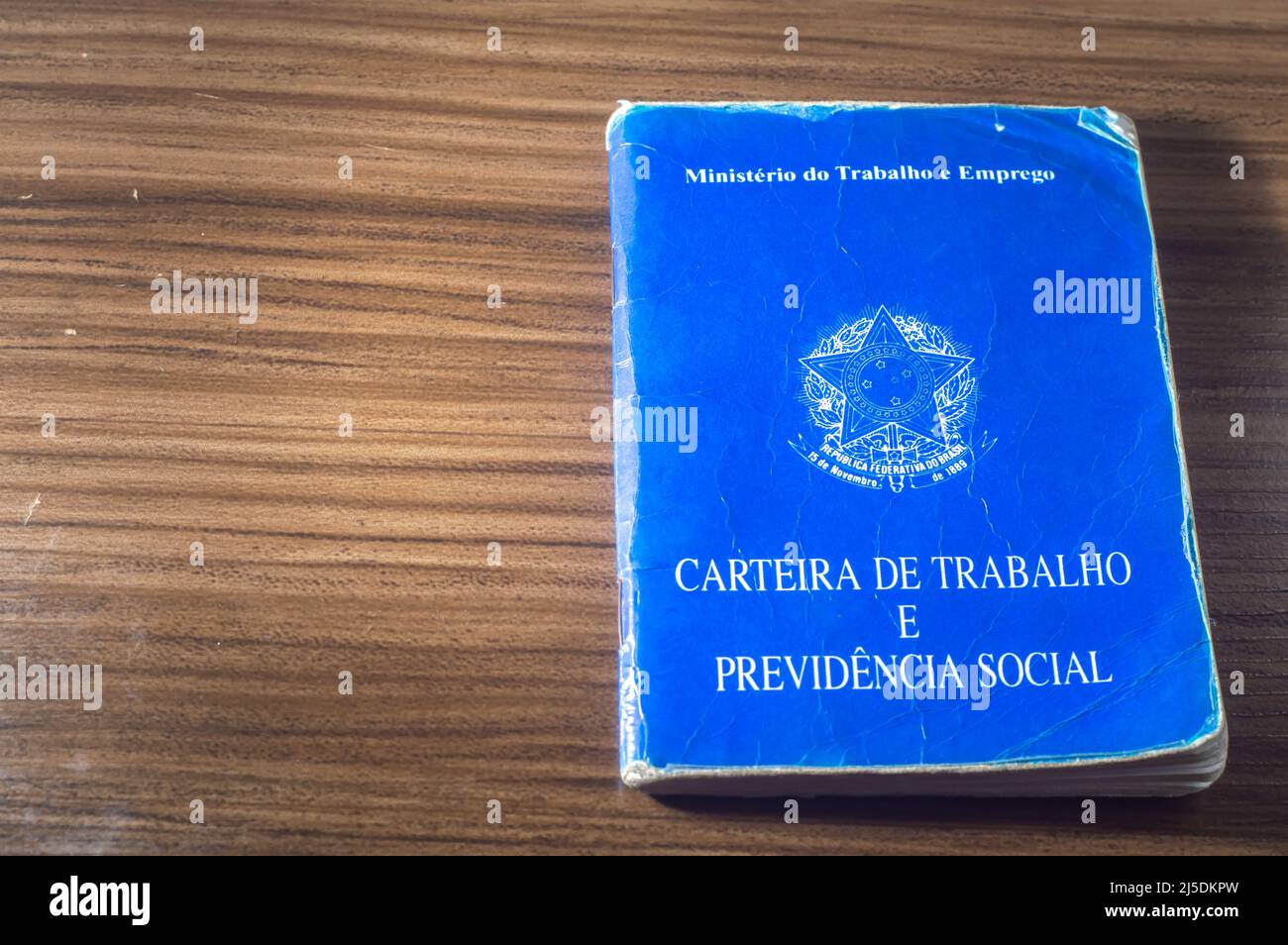 Traduzione: Repubblica Federativa del Brasile, Ministero del lavoro. Scheda di lavoro (Carteira de trabalho) accanto alle monete reali brasiliane, denaro brasiliano. Foto Stock