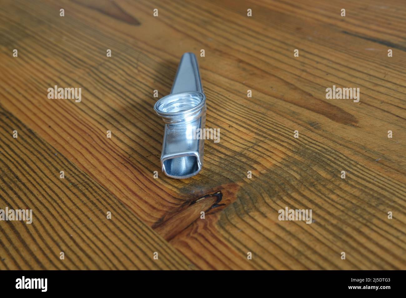 kazoo in metallo su tavola in legno Foto Stock