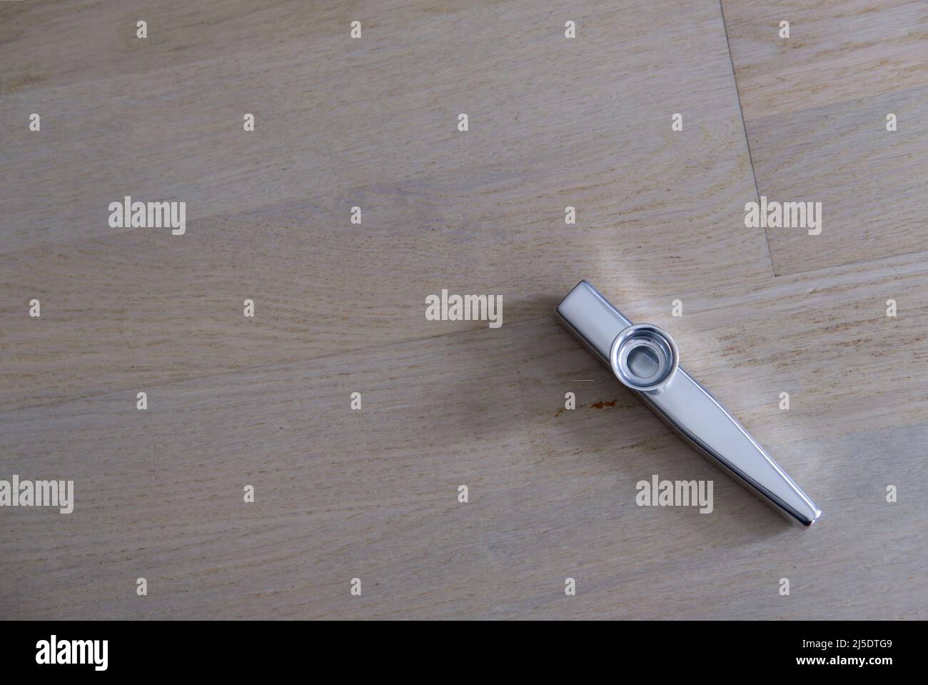 kazoo in metallo su tavola in legno Foto Stock