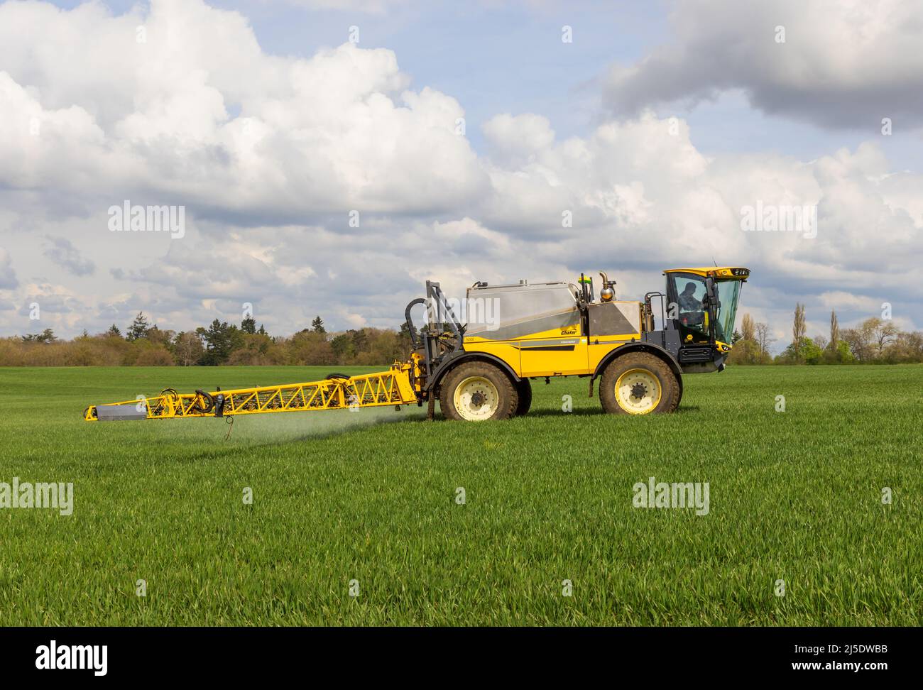 Coltivatore che usa un'irroratrice semovente in un campo all'inizio della primavera. Hertfordshire, Regno Unito Foto Stock