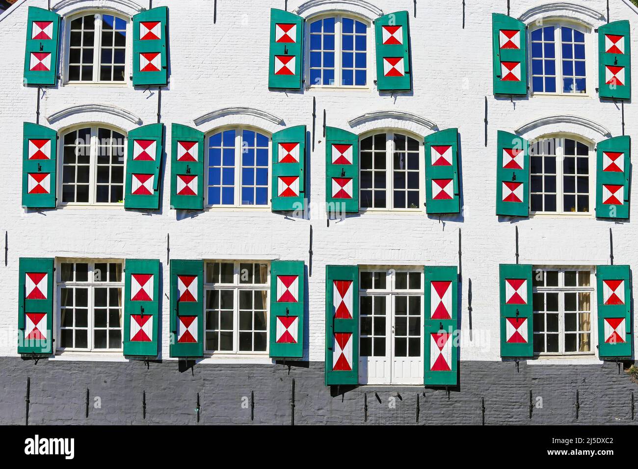 Primo piano di facciata antica casa, molte finestre di vetro, pannelli esterni aperti persiane batten dipinti in triangolo rosso bianco design - Lier, Belgio Foto Stock