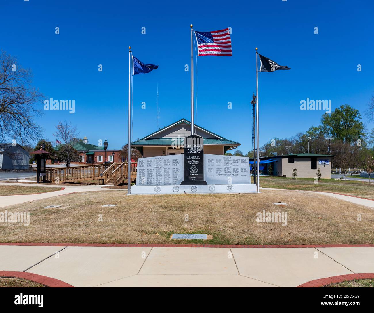 YORK, SC, USA-10 APRILE 2022: York County Veterans Memorial, monumento commemorativo, pali di bandiera, soleggiato, primavera, giorno del cielo blu. Foto Stock