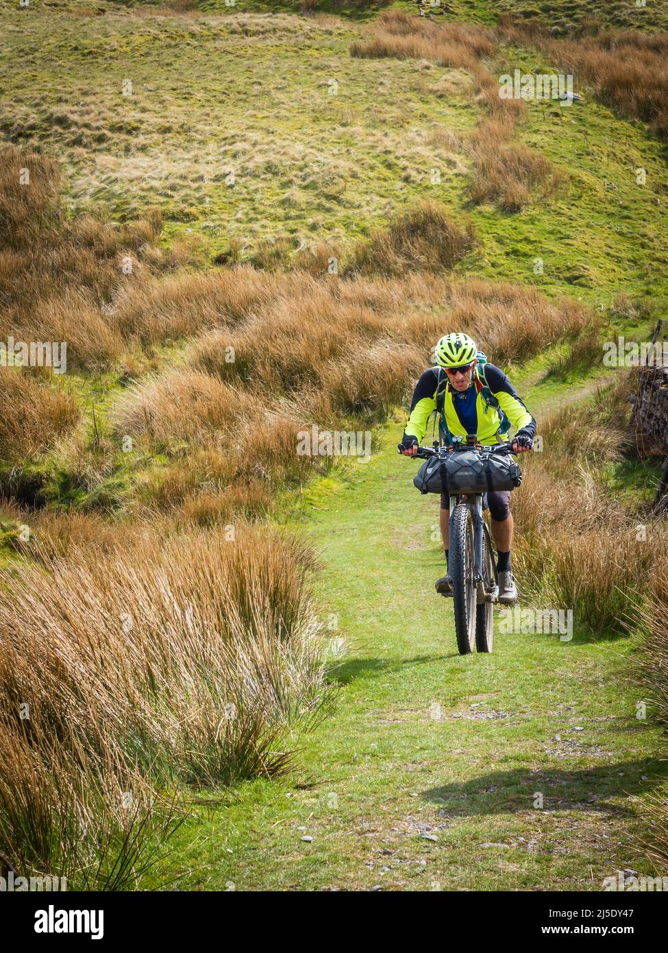 17.04.2022 Newby Head Gate, Ribblehead, North Yorkshire, Regno Unito. Ciclista sulla strada a ponte Pennine vicino a Great Knoutberry Hill ultra gara tra Arnside Foto Stock