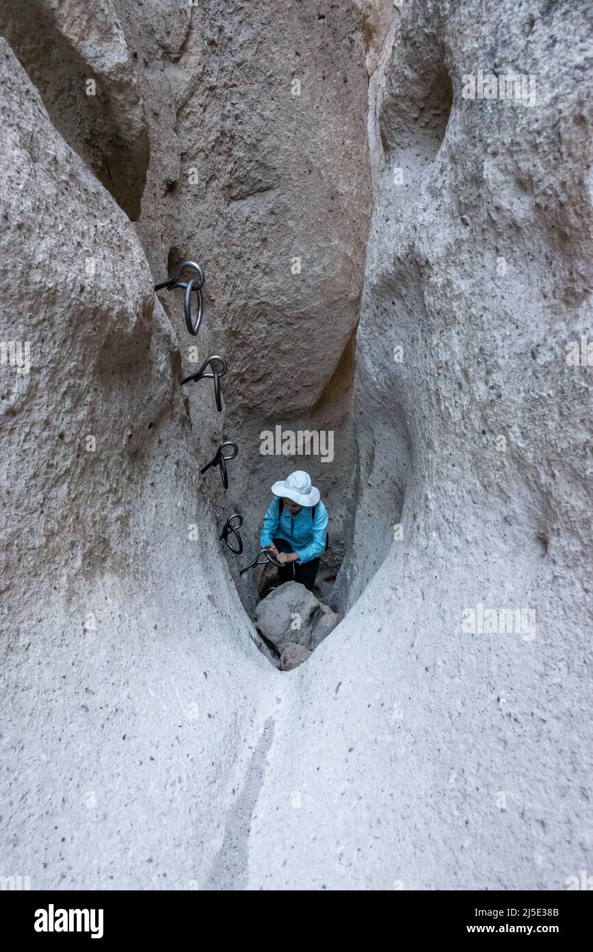 Un giovane escursionista si erge in fondo agli anelli di arrampicata in un canyon slot sul Rings Loop Trail nella riserva nazionale di Mojave, una divertente escursione in famiglia in California Foto Stock