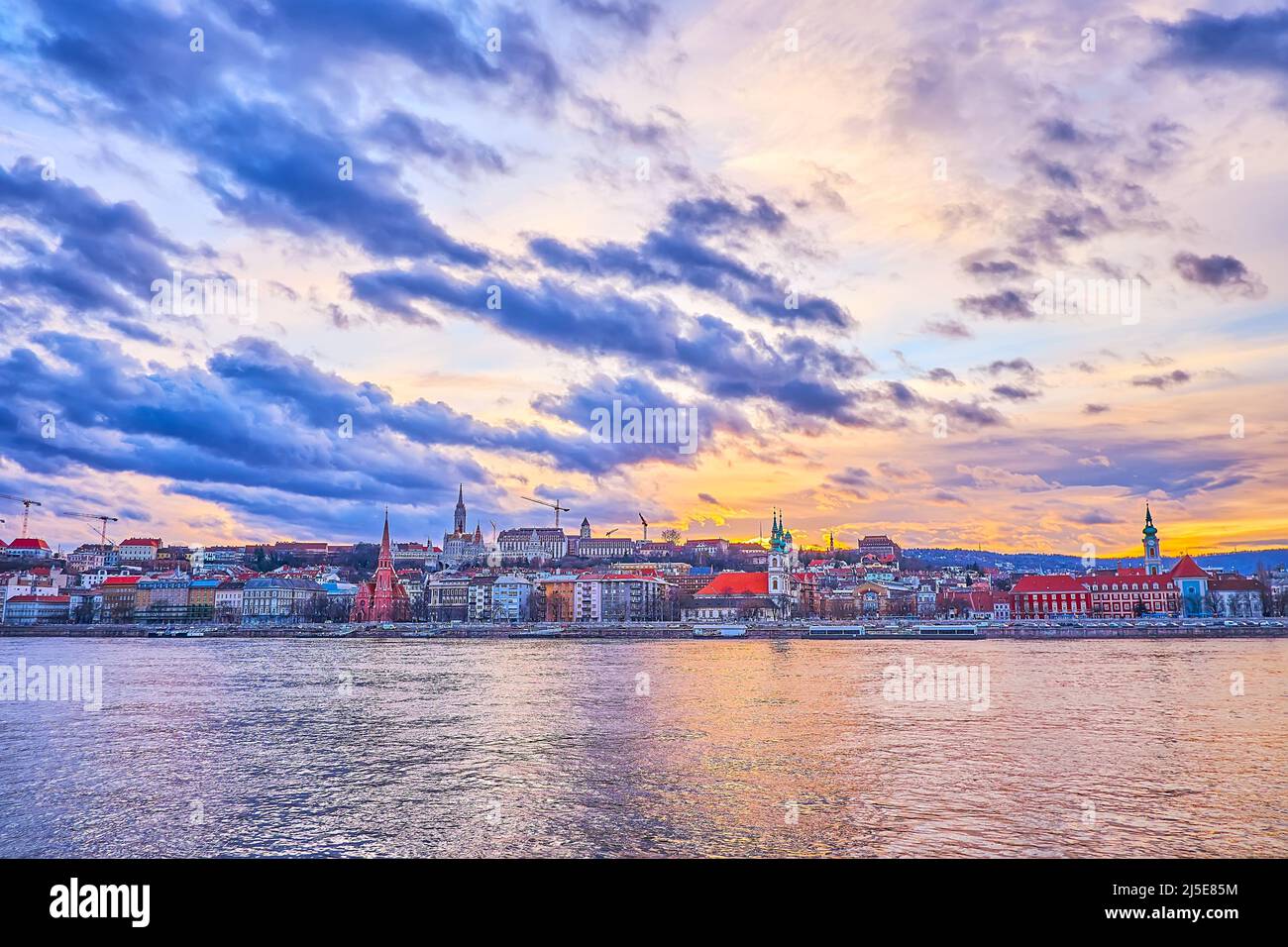 Panorama del quartiere di Buda, visto dietro il Danubio con i suoi edifici storici, le chiese e il Bastione dei pescatori in cima alla collina, Budapest, Ungheria Foto Stock