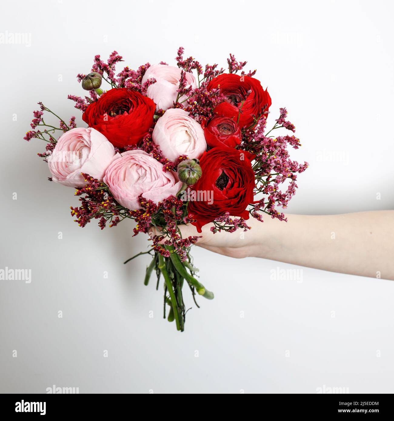 Contiene a mano un bouquet di tazzine persiane rosse e rosa Foto Stock