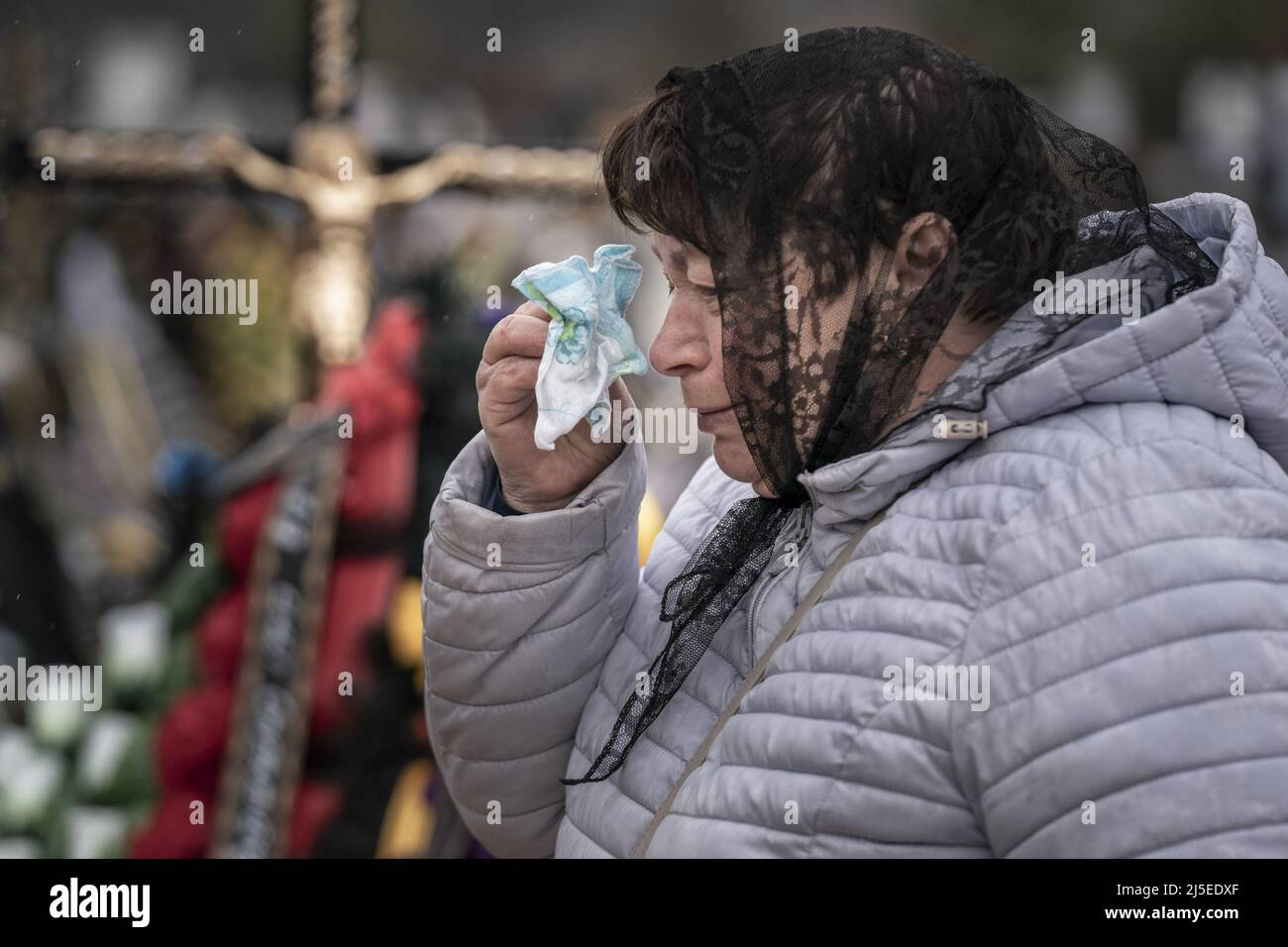 Irpin, Ucraina. 22nd Apr 2022. Kateryna Kravchenko, 61, pulisce le lacrime dopo che ha sepolto sua sorella Soroka Vira Stepanovna, 69, in un cimitero a Irpin Venerdì, 22 aprile 2022. Nonostante i danni arrecati agli appartamenti delle sorelle dagli attacchi russi, la causa della morte era l'insufficienza cardiaca. Un comandante militare a Mosca ha detto venerdì che l'obiettivo della nuova fase della guerra della Russia è quello di assumere il pieno controllo dell'Ucraina meridionale e orientale e di collegare la regione di Donbas con la Crimea via terra. Foto di Ken Cedeno/UPI . Credit: UPI/Alamy Live News Foto Stock