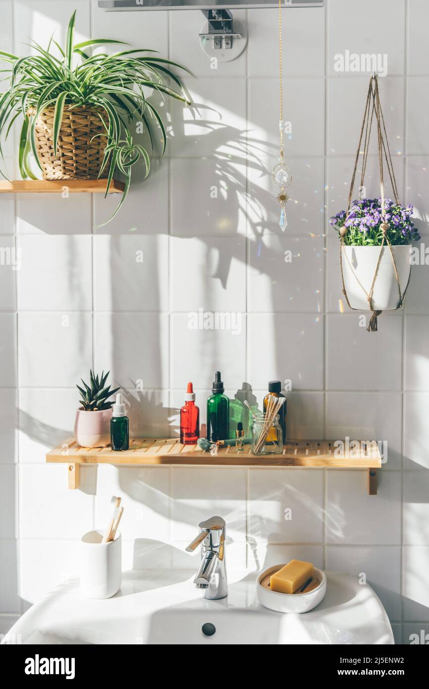 Appendere il sole catcher cristallo contro le pareti di piastrelle bianche in un bagno moderno e ecologico. Ombre sul muro Foto Stock