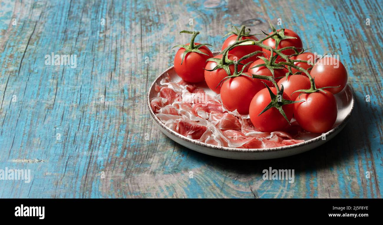 Piatto con prosciutto parma e pomodori, colazione italiana Foto Stock