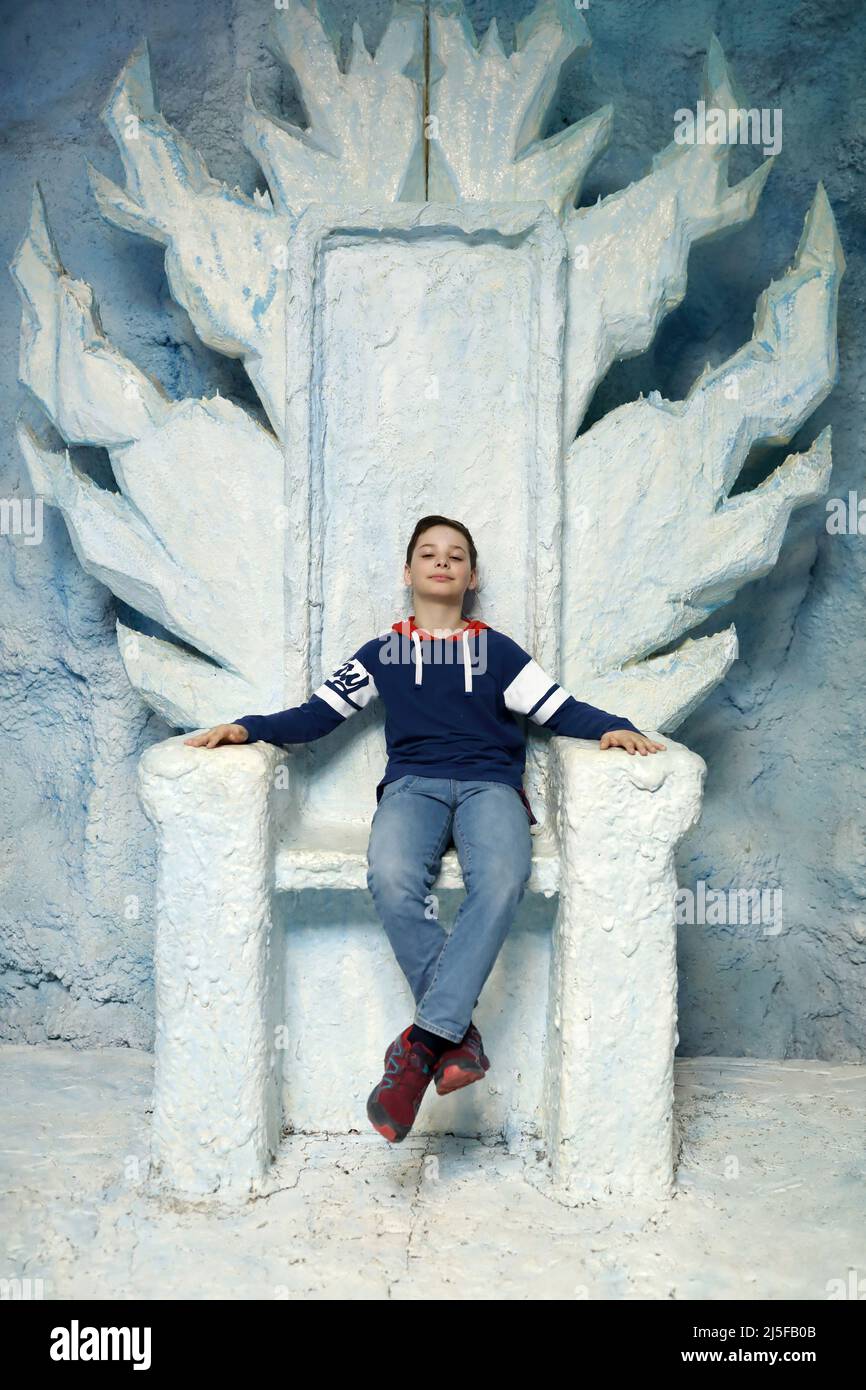 Ritratto di bambino seduto sul trono blu Foto Stock