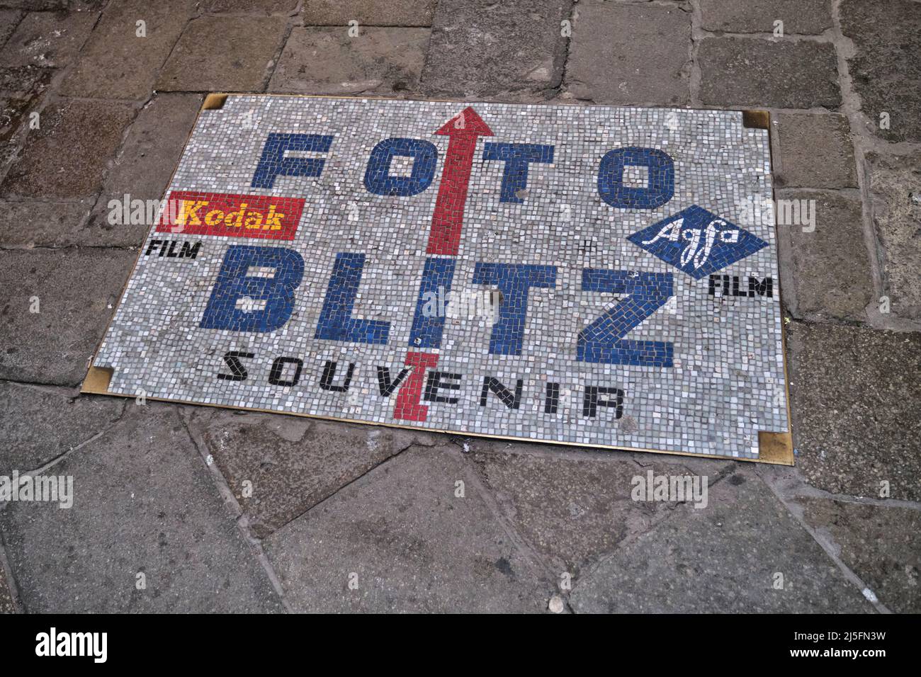 Mosaico vintage che dirige i turisti verso un negozio Kodak ormai defunto a Venezia, Italia Foto Stock