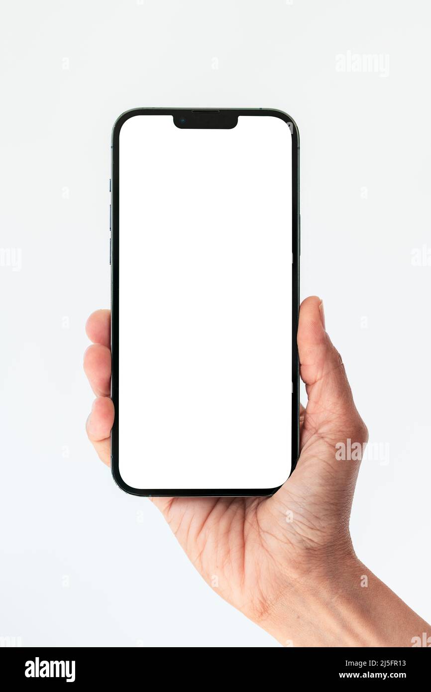 Primo piano tenere il telefono isolato su bianco, smartphone bianco schermo bianco Foto Stock