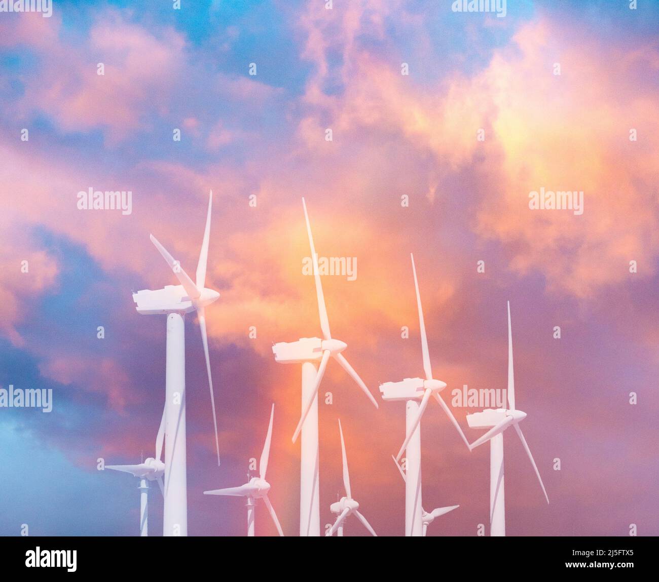 Concetto di energia rinnovabile: Turbine eoliche con arcobaleno nel cielo. Pulito, economico, elettricità, riscaldamento globale, cambiamento climatico, emissioni nette zero Foto Stock