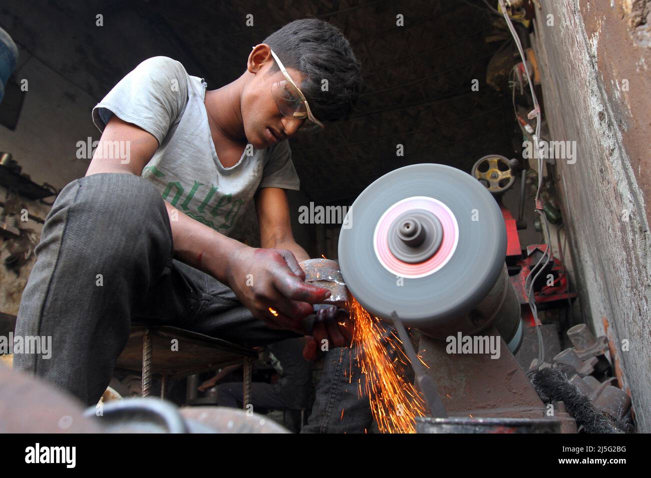 Dhaka, Bangladesh - 22 novembre 2014: I bambini del Bangladesh stanno facendo la macchina del tornio di lavoro rischiosa. Foto Stock