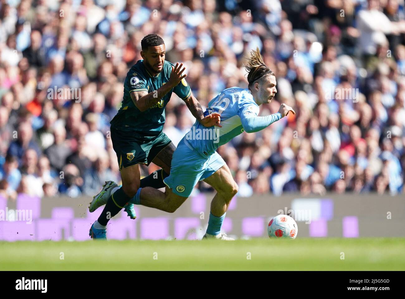 Joshua King di Watford e Jack Grealish di Manchester City (a destra) lottano per la palla durante la partita della Premier League all'Etihad Stadium di Manchester. Data foto: Sabato 23 aprile 2022. Foto Stock