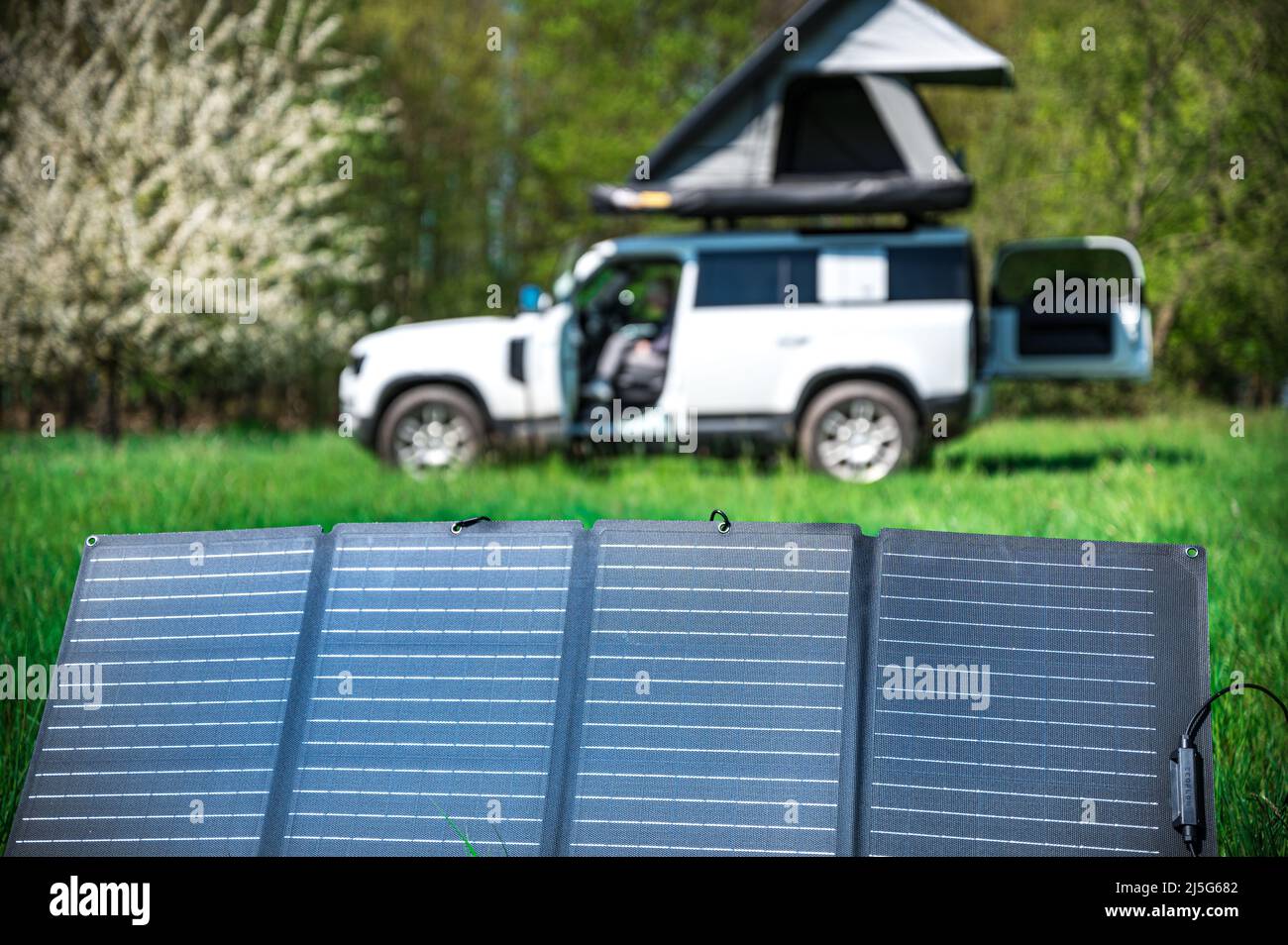 4x4 veicolo fuoristrada campeggio con tetto tenda in un meadwow con pannello solare per la generazione di energia in primo piano Foto Stock