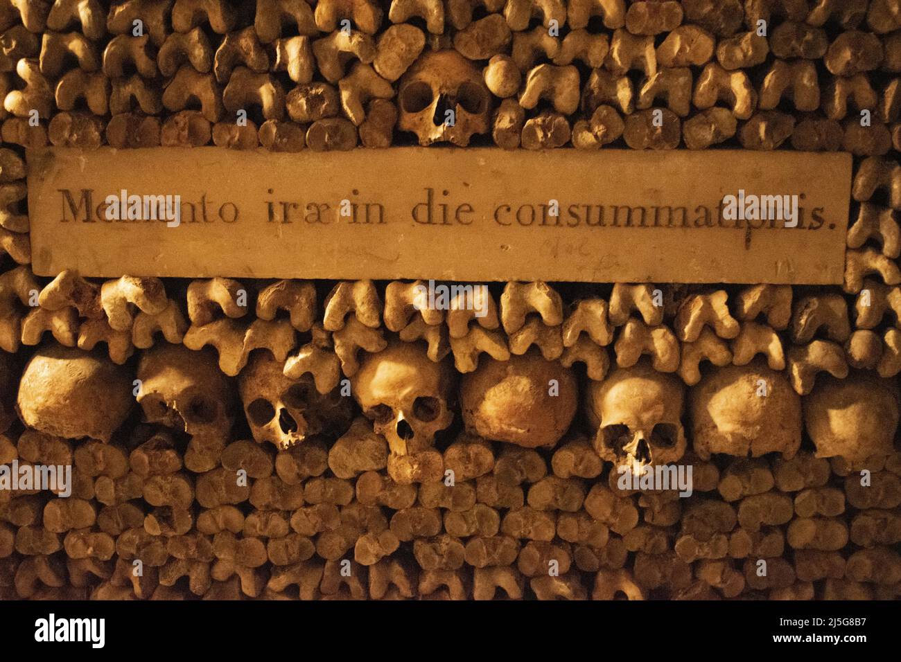 Parigi, Francia: Teschi, ossa, iscrizione latina “Ricorda l’ira della fine della giornata” nelle catacombe di Parigi, ossario in una cava sotterranea Foto Stock