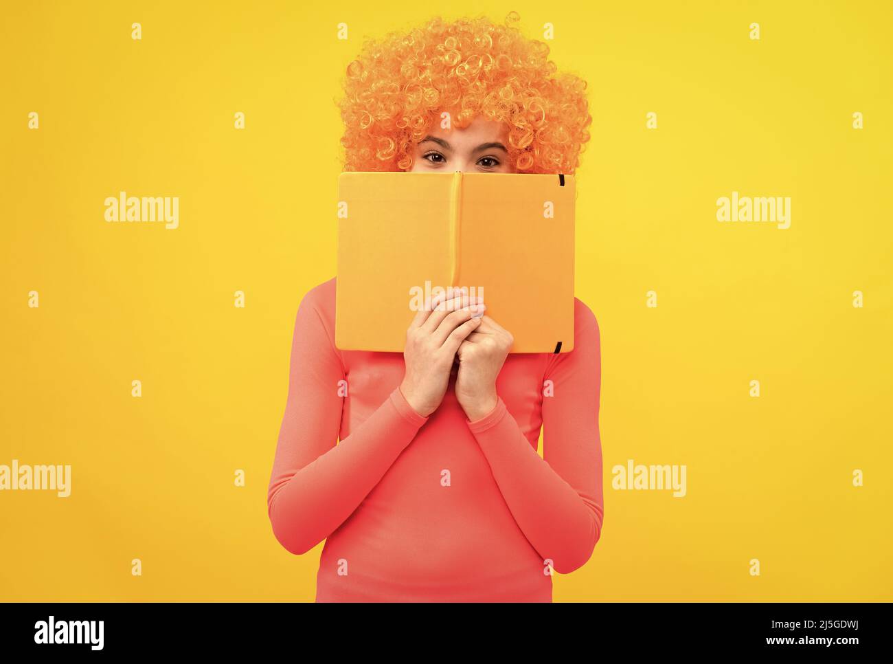 Bookworm in formazione. Funky bookworm sfondo giallo. Felice faccia di copertura del capretto con il libro Foto Stock