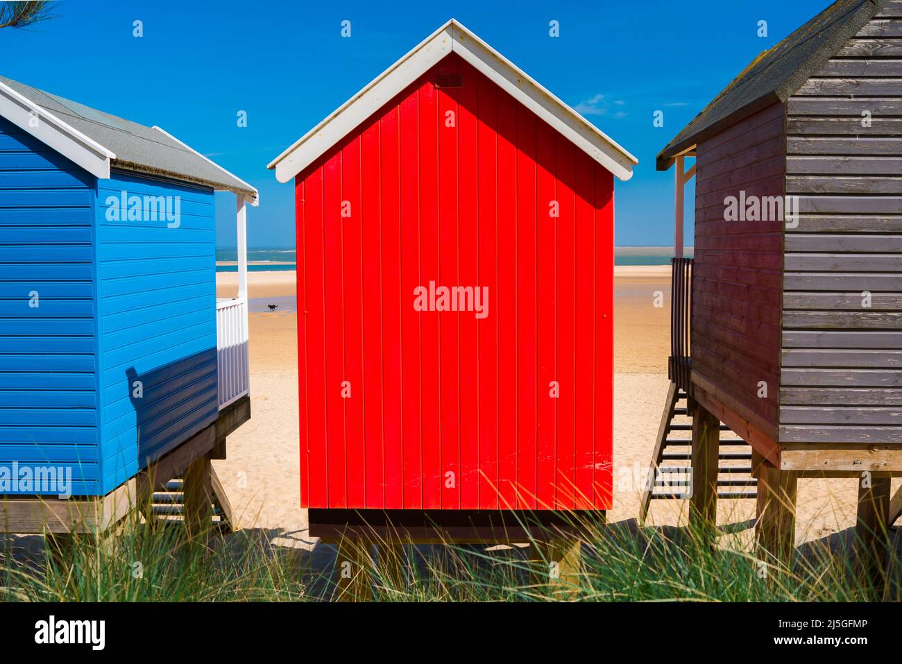 Capanna da spiaggia colorata, vista in estate di colorate capanne da spiaggia di fronte alla spiaggia di sabbia a Wells-next-the-Sea sulla costa nord di Norfolk, Inghilterra, Regno Unito Foto Stock