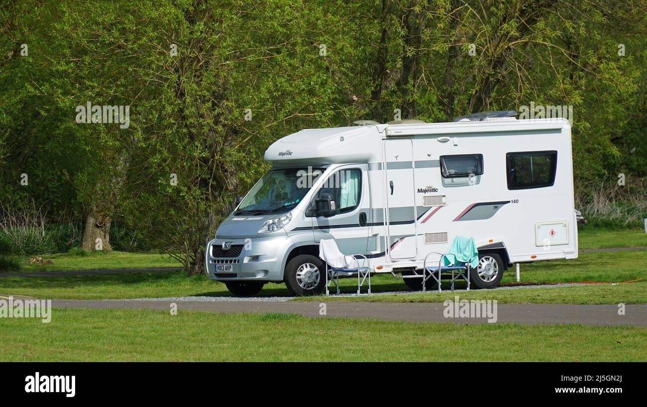 Peugeot maestoso motorhome parcheggiato in campeggio con alberi sullo sfondo. Foto Stock