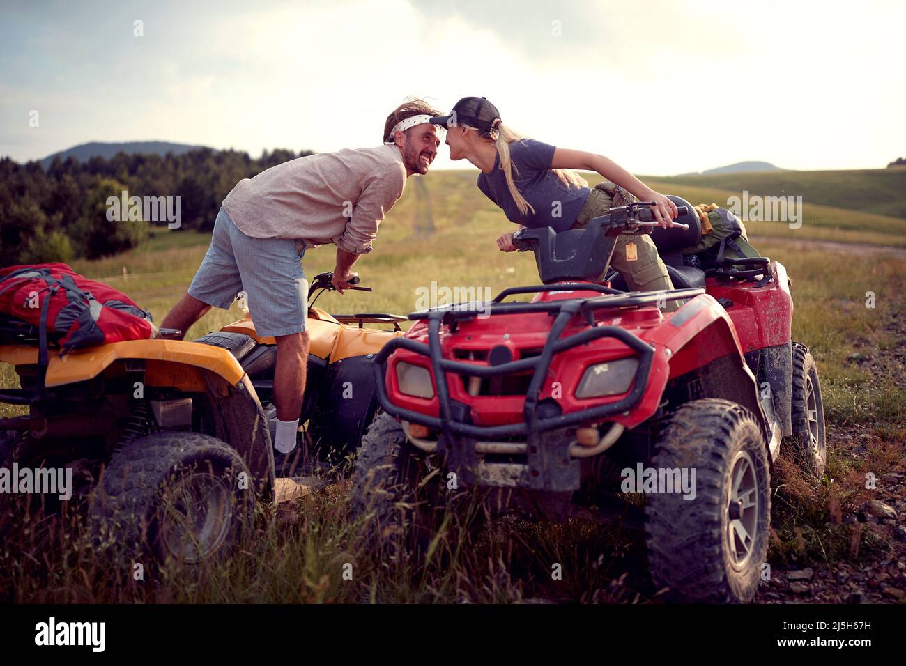 Due amanti che guidano i quad insieme nella natura; concetto di vacanza attiva Foto Stock