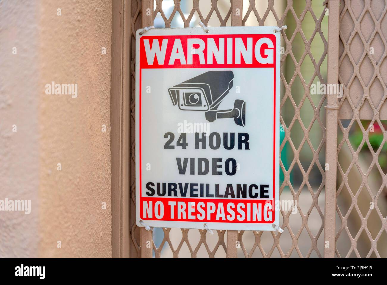Insegne per telecamere di sorveglianza su ringhiere metalliche in rete a San Francisco, California. 24 ore di videosorveglianza nessun segno di tresspassing contro il li Foto Stock