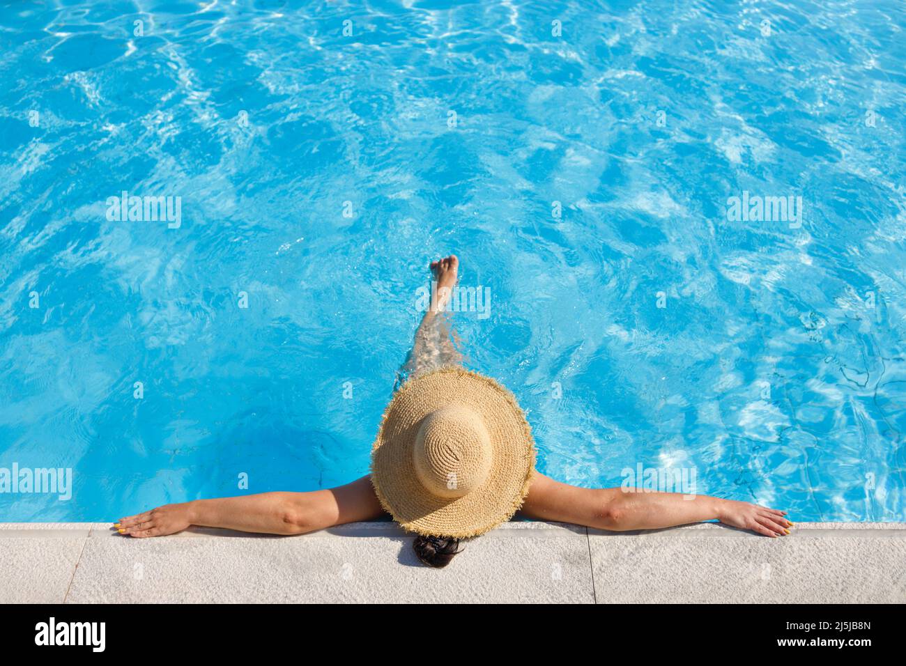 vista dall'alto della donna in cappello di paglia rilassante in piscina Foto Stock