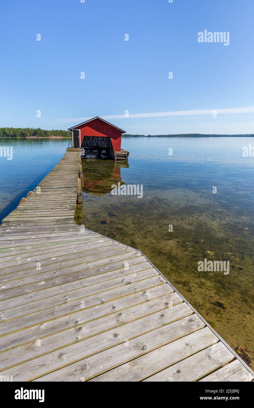 Molo di legno, boathouse e oceano nelle isole Åland, Finlandia, in una giornata di sole in estate. Foto Stock