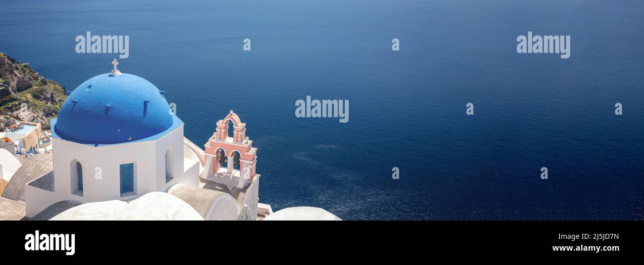 Santorini, Grecia. Panorama della chiesa greco-ortodossa con cupola blu e mare caldera blu nel villaggio di Oia, vista aerea. Spazio di copia, modello scheda Foto Stock