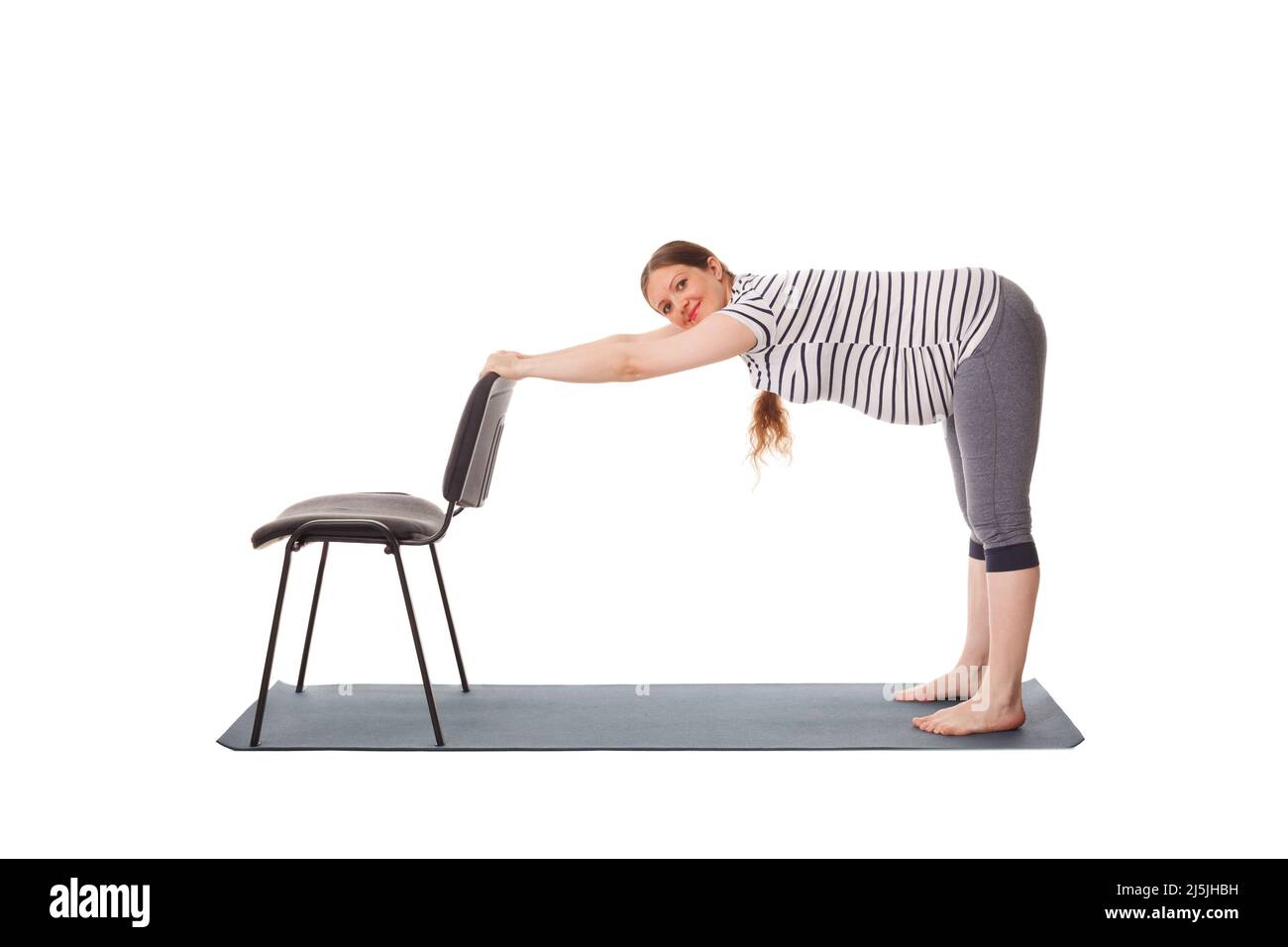 Donna incinta che fa yoga asana Utttanasana Foto Stock